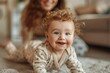 Happy 8 month caucasian baby in beige pajamas jolly crawls on the stomach across the floor looks and smiles at camera. First steps of infant. Child development. Child care, babyhood