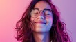 © iuricazac - A young person with closed eyes smiling wearing glasses and with vibrant pink and purple hair set against a soft pink background.