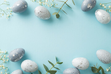 Wall Mural - Festive Easter composition: Directly top view of beautiful grey eggs, gypsophila blooms, and eucalyptus branches arrayed on a pale blue ground, with a vacant spot for textual content or advertising