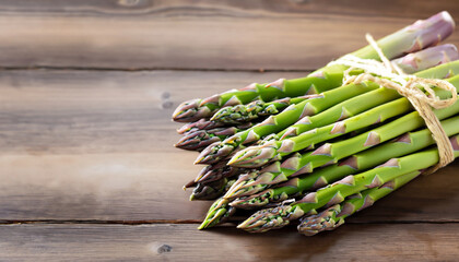 Wall Mural - Bunch of fresh asparagus on wooden table; selective focus and free space for text