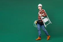 Young Laborer Electrician Man Wear Red Shirt Hardhat Hat Work Carrying Cables Stepladder Isolated On Plain Green Background. Instruments Accessories For Renovation Apartment Room. Repair Home Concept.