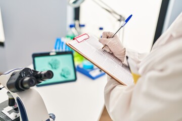 Sticker - Young caucasian woman gynecologist looking embryo on touchpad writing on document at laboratory