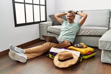 Poster - Middle age grey-haired man using laptop looking for travel at home