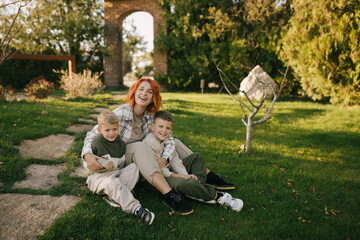 Happy mother and her two sons having fun spending time together outdoors.