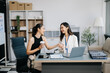 © Nuttapong punna - Businesswomen work and discuss their business plans. A woman employee explains and shows her colleague the results paper