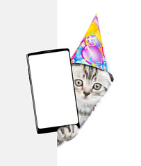 Poster - Cute kitten wearing party cap shows big smartphone with blank screen from behind white banner. isolated on white background