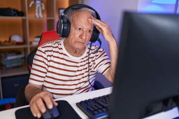 Canvas Print - Middle age grey-haired man streamer stressed using computer at gaming room