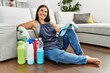 © Krakenimages.com - Young beautiful hispanic woman smiling confident sitting on floor with clean products at home
