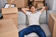 © Krakenimages.com - Young man sitting on sofa relaxed with hands on head at new home