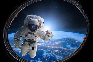 Wall Mural - astronaut in outer space from porthole on background of the earth. elements of this image furnished 