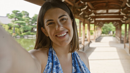 Sticker - Confident hispanic woman, an all-smile beautiful brunette, enjoys taking a fun selfie at traditional japanese heian jingu shrine, kyoto.