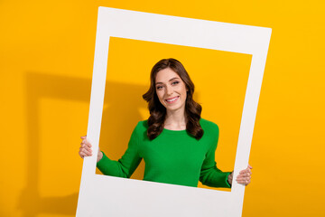 Canvas Print - Photo of young gorgeous girlfriend in green jumper holding paper frame memories window at party isolated on yellow color background