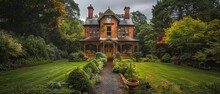 A Classic Victorian House Surrounded By A Lush Garden, Showcasing The Charm And Detail Of Historical Architecture.

