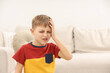 © New Africa - Little boy suffering from headache at home, space for text