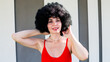 © ALEXEY - Portrait of a woman with black lush hair near striped wall.