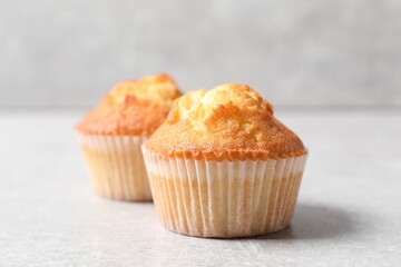 Wall Mural - Tasty muffins on light grey table, closeup. Fresh pastry
