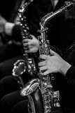 Fototapeta  -  Hands of a girl playing the saxophone in an orchestra in black and white