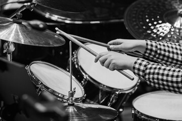 Wall Mural - Hands of a girl playing a drum kit in black and white