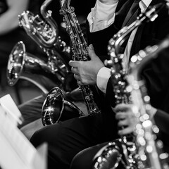 Sticker - A fragment of a saxophone in the hands of a musician in an orchestra in black and white