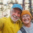 © Daniel - Head shot portrait close up of cute couple of old seniors taking a selfie together in the mountain forest looking at the camera smiling having fun enjoying. Two mature people hiking.