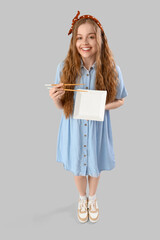 Canvas Print - Beautiful young woman with empty plate and chopsticks on grey background