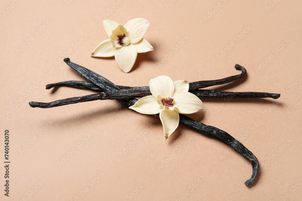 Aromatic vanilla sticks and flowers on brown background