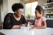 © Marharyta Tsapenko - Mother and Daughter Laughing While Doing Science Experiment