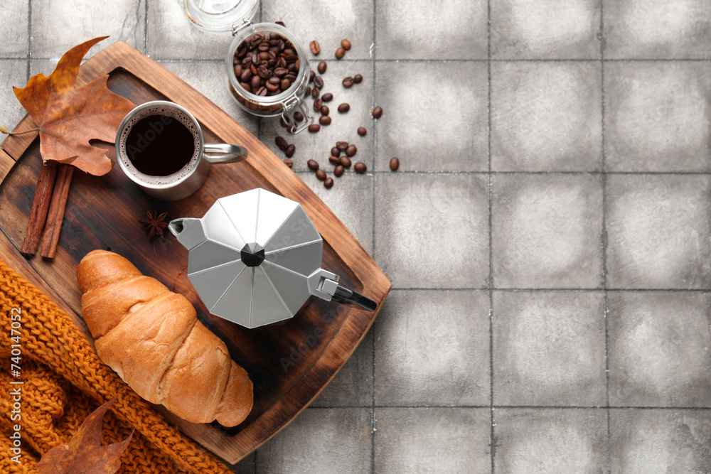 Composition with cup of aromatic coffee, beans and croissant on grunge tile background
