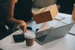 © ARMMY PICCA - businesswoman start small business and successful SME entrepreneurs asian woman hoding boxs works from home delivering parcels online. SME delivery concept and packaging