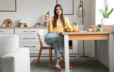 Canvas Print - Pretty young woman with fresh fruits in basket at home