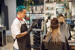 © Friends Stock - Professional colorist putting on gloves before coloring hair in beauty salon