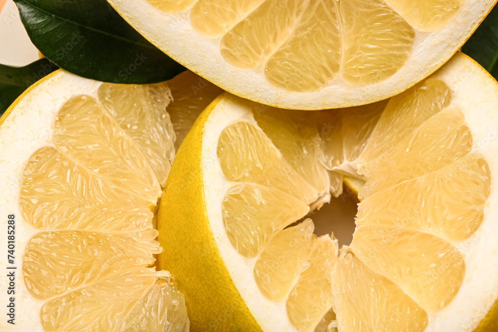 Sweet pomelo slices and leaves as background