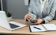 © RomanR - business woman counting money dollar at modern office