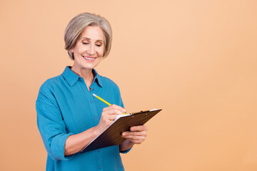 Sticker - Portrait of positive person with white gray hair wear stylish shirt write checklist with pen in arm isolated on beige color background