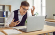 © Studio Romantic - Portrait of dissatisfied stressed angry excited young business man in suit sitting at the desk on his workplace in office looking at laptop monitor screen with disappointed face expression.
