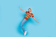 © deagreez - Full size photo of funny positive gorgeous woman dressed knit t-shirt denim pants dancing on tiptoes isolated on blue color background
