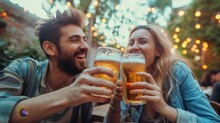A Man And Woman Holding Glasses Of Beer
