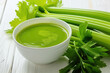 Fresh celery soup in bowl on wooden table