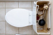 Residential home bathroom toilet tank plumbing repair. Replacing old leaking restroom lavatory flush valve.