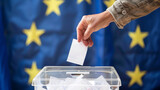 Fototapeta Mapy - Man throwing his vote into the ballot box. Elections to the European Parliament