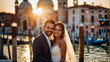 © Wabisabi - Bella coppia di sposi in vacanza in Italia a Venezia posa per una foto al tramonto vicino ad un canale con gli abiti del matrimonio, luna di miele