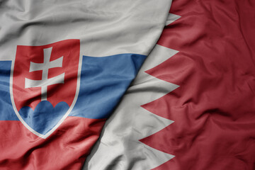 big waving national colorful flag of bahrain and national flag of slovakia .