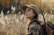 © Road Red Runner - A woman standing in a field with a rifle, ready for hunting.