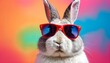 © Antonina - cool easter bunny with glasses on a rainbow background. Easter holiday
