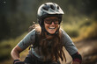 Lachende junge Frau mit Helm beim Mountainbiken, Frau auf Fahrrad beim Downhill