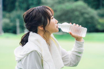 Poster - 運動中・ウォーキングの休憩にペットボトルの水を飲むアジア人女性の横顔
