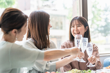 Canvas Print - 女子会でレストラン・カフェ・飲食店でシャンパンを持って乾杯する女性達（アジア人）
