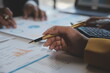 © Sirikarn Rinruesee - Financial analysts analyze business financial reports on a digital tablet planning investment project during a discussion at a meeting of corporate showing the results of their successful teamwork.