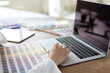 © littlepigpower - Graphic designer using color swatch to do his work at modern office. Architect using work tools and sample colour catalog.