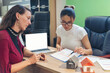 © aFotostock - Businesswoman real estate house agent discuss to customer. Team diversity women selling house real estate agent at office desk. Women working home insurance mortgage sale apartment realtor dealership